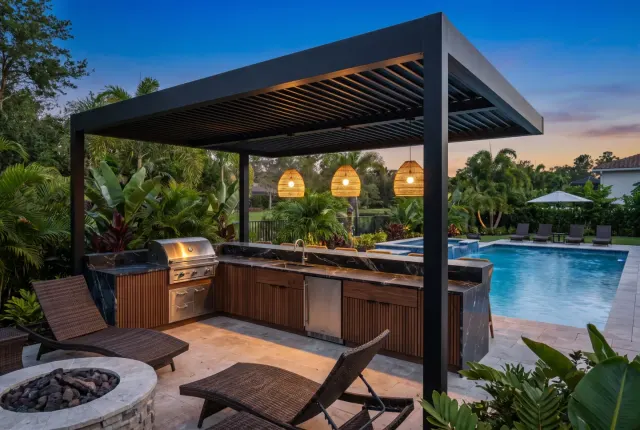 Outdoor kitchen under a black canopy at dusk