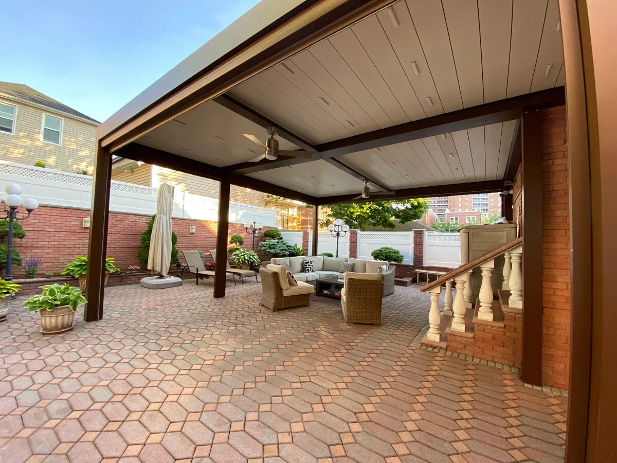 The same courtyard pergola with the blades closed into a solid ceiling, downlights set into the plane — photograph
